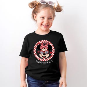 a little girl wearing a minnie mouse shirt