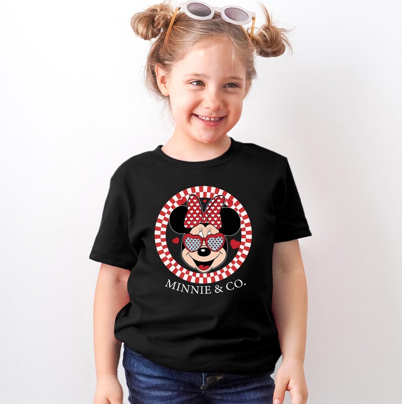 a little girl wearing a minnie mouse shirt