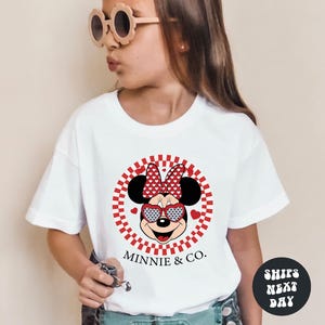 a little girl wearing a minnie mouse shirt