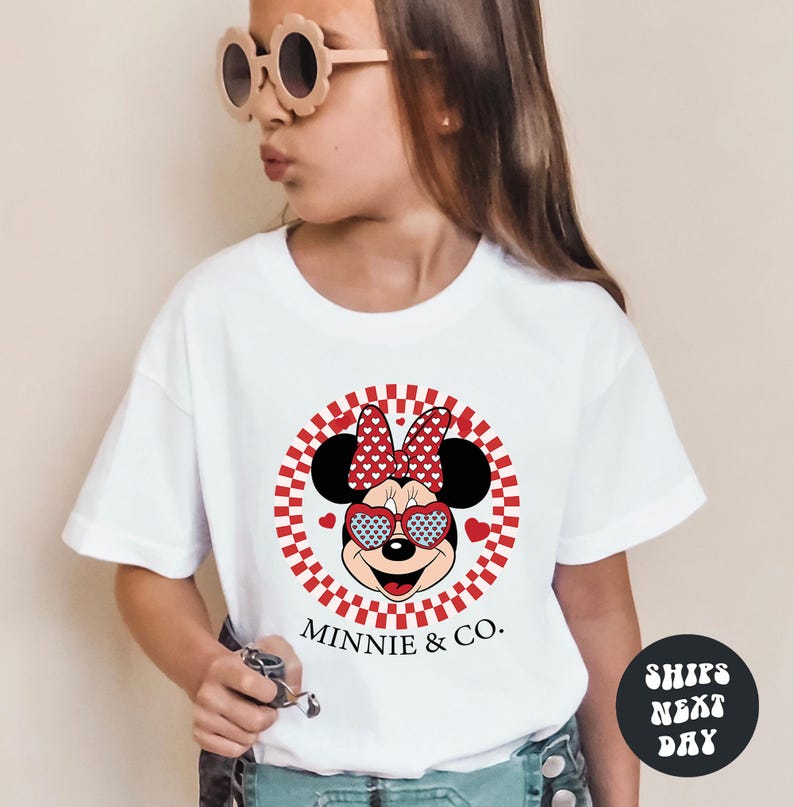 a little girl wearing a minnie mouse shirt