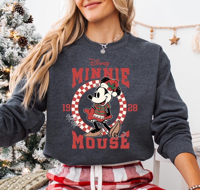 A woman wearing a gray sweatshirt with a graphic of Mickey Mouse and the text "Disney MINNIE MOUSE" printed on it.