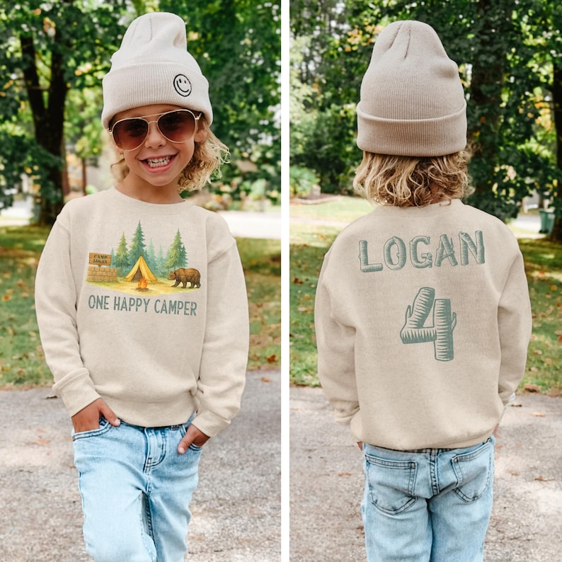 a little boy wearing a sweater that says logan
