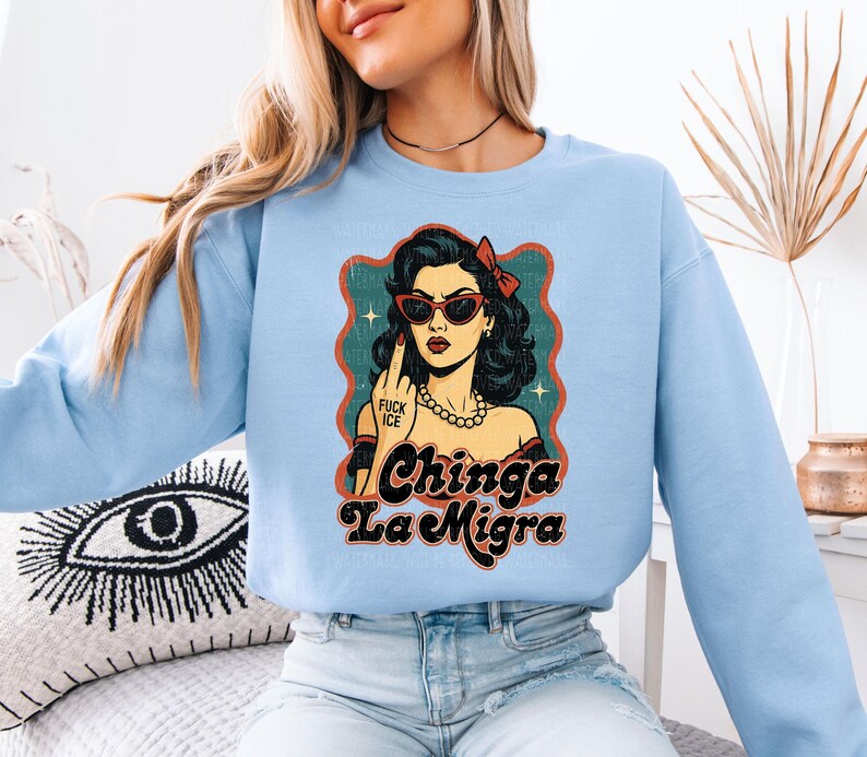 a woman wearing a blue sweatshirt with a picture of a woman wearing sunglasses
