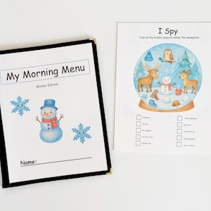 May include: A winter-themed activity set featuring a "My Morning Menu" booklet with a snowman and snowflakes, and an "I Spy" game with a snow globe illustration. The booklet has a black border and gold corners.