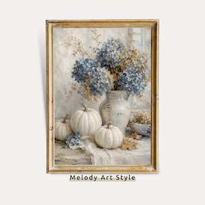 Op de afbeelding: Een ingelijste kunstdruk met een stilleven van drie witte pompoenen en een keramieken vaas gevuld met blauwe en crèmekleurige hortensia's. De compositie bevat een kleine kom met gedroogde planten en verspreide herfstbladeren.