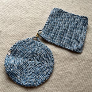 May include: Two blue and white crocheted pot holders. One is round and the other is square.