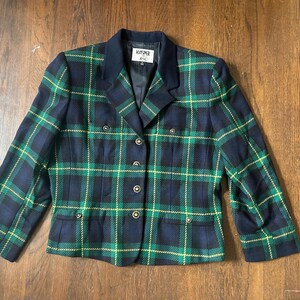 May include: A plaid blazer in navy blue, green, and yellow. The jacket has a notched collar, double-breasted button closure, and two front pockets. The label reads "KASPER 4XL".
