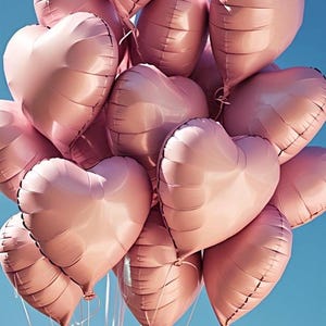 May include: A bunch of pink heart-shaped balloons against a blue sky.