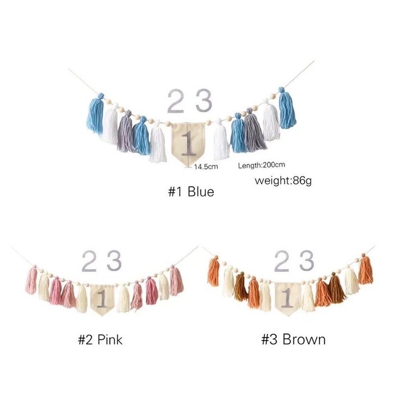 Puede incluir: Una guirnalda decorativa con borlas azules, grises y blancas, y una banderola beige con el n&uacute;mero 1. La guirnalda mide 200 cm de largo y pesa 86 g. Tambi&eacute;n disponible en rosa y marr&oacute;n.