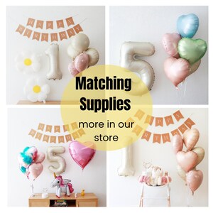 May include: A set of party decorations for a birthday celebration. The decorations include a banner that says "Happy Birthday", a set of balloons in the shape of numbers, and a set of heart-shaped balloons in various pastel colors.