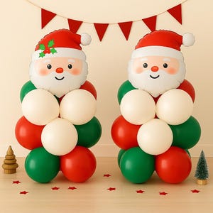 May include: Two Christmas balloon decorations shaped like Santa Claus. Each Santa has a red hat, white beard, and a smiling face. The bodies are made of red, green, and white balloons. A festive banner and star confetti complete the holiday scene.