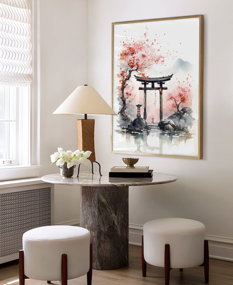 May include: A watercolor painting of a Japanese garden scene with a red torii gate, cherry blossoms, and a mountain in the background. The painting is framed in gold and hangs on a white wall.