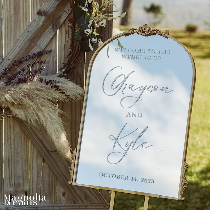 Stylish gold arch and flourish mirror displaying a personalized vinyl scripted welcome sign, adding a touch of sophistication to your wedding or engagement celebration personalized vinyl scripted welcome sign perfect for elegant engagement events