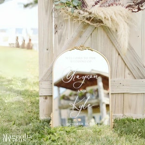 Stylish gold arch and flourish mirror displaying a personalized vinyl scripted welcome sign, adding a touch of sophistication to your wedding or engagement celebration personalized vinyl scripted welcome sign perfect for elegant engagement events