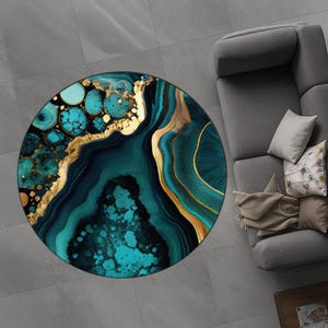 Könnte beinhalten: Ein runder Teppich mit einem abstrakten Design in Türkis, Gold und Marineblau. Der Teppich hat eine marmorierte Optik mit goldenen Akzenten und einem türkisartigen Steinmuster. Er liegt auf einem grau gefliesten Boden.