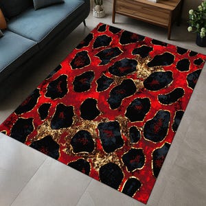 May include: Red and black area rug with a leopard print pattern. The rug has gold accents and a shiny finish.