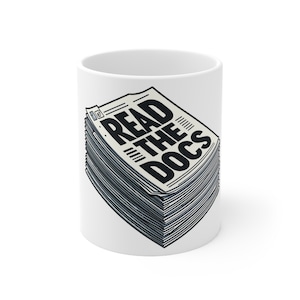 Peut inclure: Une tasse en céramique blanche avec une illustration en noir et blanc d'une pile de journaux avec le texte "READ THE DOCS" imprimé sur le devant.