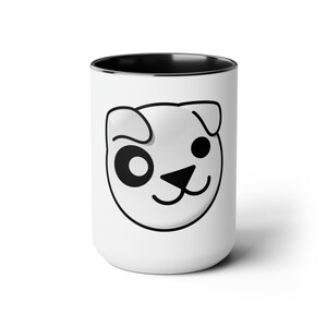 Könnte beinhalten: Weiße Keramiktasse mit schwarzem Rand und einer schwarz-weißen Cartoon-Hundegesichts-Illustration.