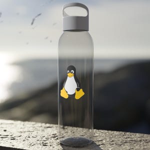 May include: A clear plastic water bottle with a white lid and a carrying handle. The bottle has a black and white penguin sticker on the front.