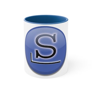 Peut inclure: Une tasse en céramique blanche avec un bord bleu et un cercle bleu avec une lettre noire "S" au centre. La tasse est sur un fond blanc.