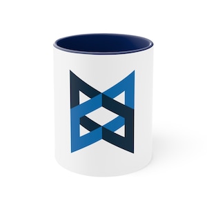 May include: White ceramic mug with a blue and black geometric design. The mug has a dark blue interior.