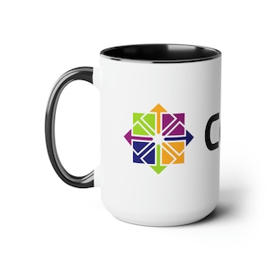 May include: White ceramic coffee mug with a black handle and interior rim. The mug features a colorful geometric design with arrows in shades of green, purple, orange, and blue. The word "CO" is printed in black on the side.