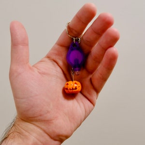 Handgemaakte Jack-O'-Lantern-sleutelhanger. Licht op in het donker, laadt op met elk licht, maar extra leuk met het meegeleverde uv-licht! Superleuk voor Halloween!