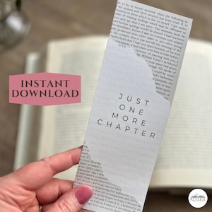 May include: A white bookmark with the text "JUST ONE MORE CHAPTER" in black, with a background of book pages. The words "INSTANT DOWNLOAD" are in a pink box. A hand is holding the bookmark.
