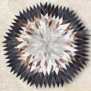 Peut inclure: Un tapis rond en peau de vache multicolores avec un motif en étoile. Le tapis est fait de différentes nuances de brun, blanc et noir.