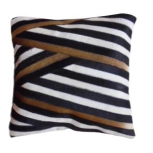 May include: A black and white striped throw pillow with brown stripes. The pillow is made of a soft, plush fabric.