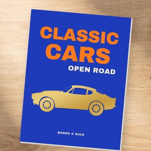 Peut inclure: Un livre rectangulaire à la couverture bleu vif présentant le texte orange CLASSIC CARS, le texte blanc OPEN ROAD et une silhouette dorée de voiture de sport vintage. Le bas de la couverture affiche le texte blanc BORED & RICH en police sobre.