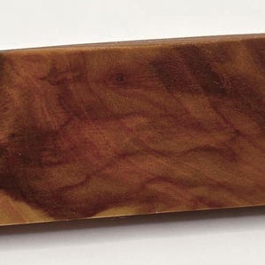 May include: A handcrafted wooden serving board with a unique, curved design. The board is made of a rich, reddish-brown wood, showcasing the natural grain and texture. The board's shape is rectangular with a curved edge, adding a touch of elegance to any kitchen.