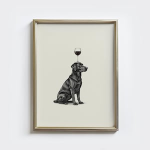 May include: A framed print featuring a black Labrador Retriever with a wine glass balanced on its head. The dog is sitting, and the glass is filled with red wine. The artwork is in black and white, with a neutral background.