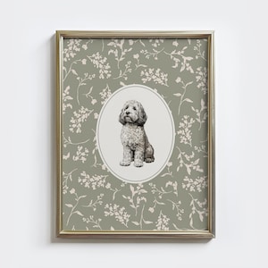 May include: Framed print featuring a seated dog illustration within an oval frame. The dog is depicted in shades of gray and white. The background is a sage green color with a floral pattern. The frame is gold.