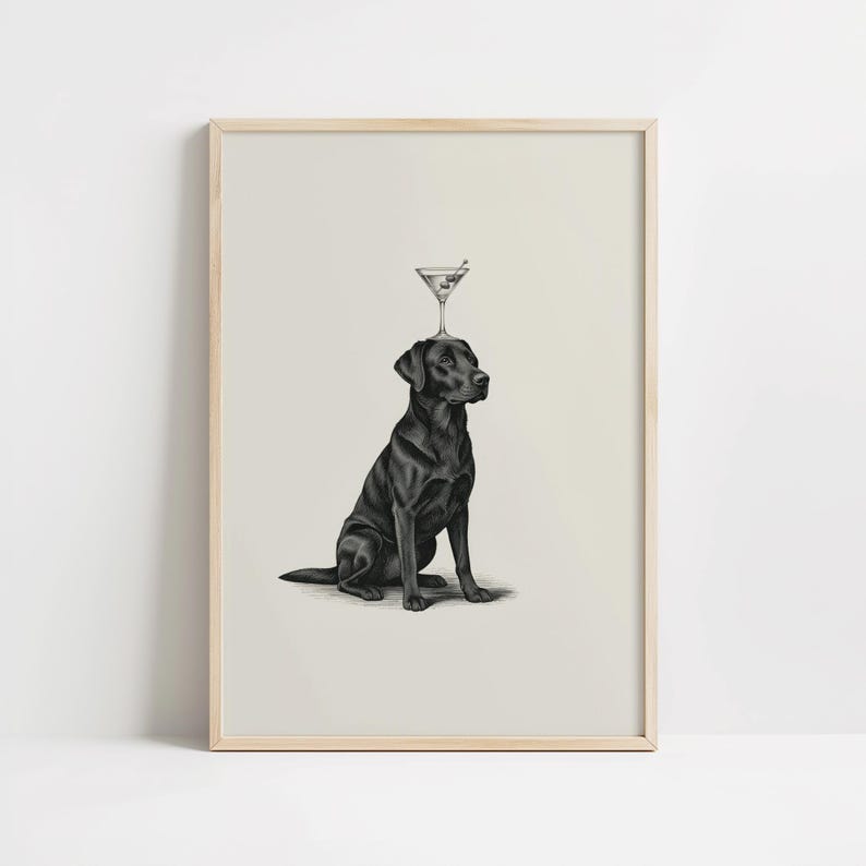 May include: A framed print featuring a black Labrador Retriever sitting upright with a martini glass balanced on its head. The artwork is a black and white illustration with a light background and a wooden frame.