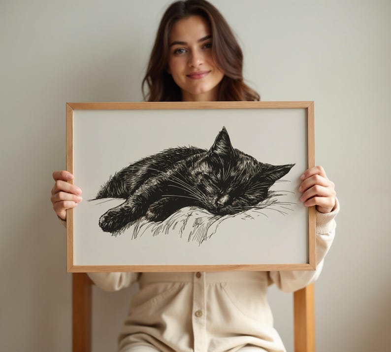 May include: A black and white line drawing of a cat sleeping on a pillow. The drawing is framed in a light wood frame.
