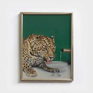 May include: Framed artwork featuring a leopard drinking from a champagne glass. The leopard has a spotted coat and green eyes. A champagne bottle pours into the glass. The background is a solid dark green.