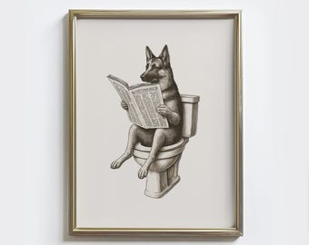 May include: Framed art print featuring a German Shepherd dog sitting on a toilet and reading a newspaper. The artwork is in black and white, with a humorous theme. The frame is gold.