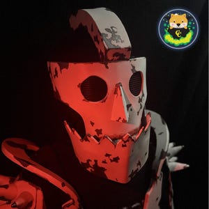 May include: A white and red skull-shaped mask with a jagged edge and a distressed paint finish. The mask has two eye holes and a pointed nose.