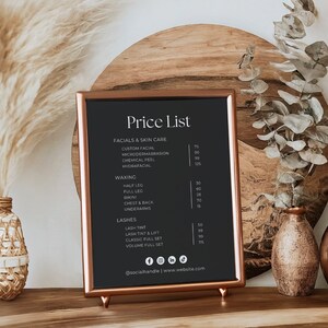 Puede incluir: Un letrero de pizarra negra con marco y soporte de cobre, que muestra una lista de precios para tratamientos faciales, depilaci&oacute;n con cera y servicios de pesta&ntilde;as. El letrero est&aacute; sobre una superficie de madera con hierba de la pampa seca y ramas de eucalipto en jarrones.
