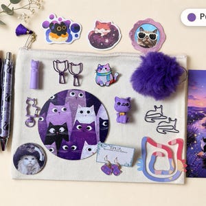 May include: A beige canvas pouch containing purple-themed cat stationery and accessories, including two pens, stickers, cat-shaped paper clips, a purple pom-pom, a cat figurine, a round coaster, earrings, and a bookmark featuring a cat by a stream.