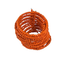 May include: Orange beaded bracelet with a spiral design. The bracelet is made of many small beads that are woven together to create a thick, textured look.