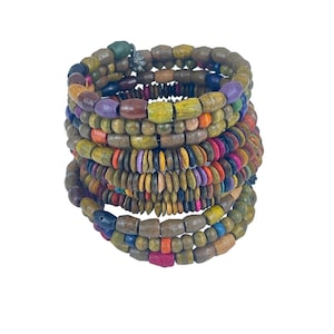Puede incluir: Un conjunto de pulseras de cuentas de madera de colores en tonos verdes, marrones, amarillos, azules y rojos. Las pulseras están hechas de cuentas de diferentes formas y tamaños.