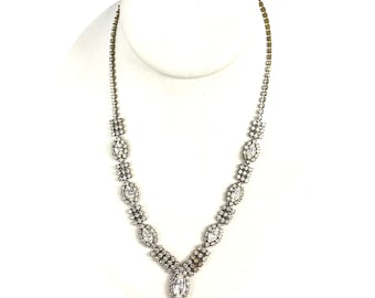 May include: A silver tone necklace with a teardrop-shaped pendant and a row of marquise-shaped stones.