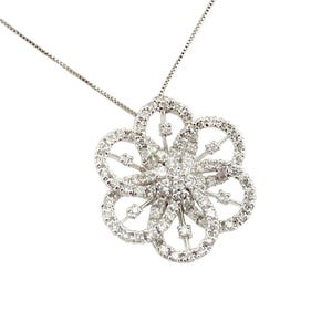 May include: A silver necklace featuring a flower-shaped pendant. The pendant is encrusted with numerous small, clear gemstones, creating a sparkling effect. The flower design has six petals and a central cluster of stones.