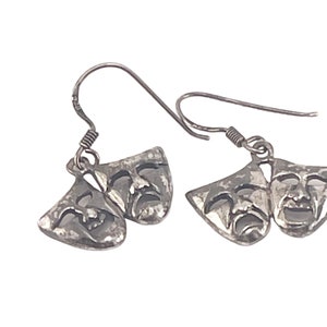 Op de afbeelding: Zilveren oorhangers met een paar theatermaskers, een lachend en een huilend.