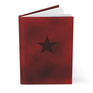May include: A red hardcover journal with a black star on the front cover.