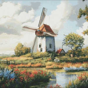 May include: A white windmill with a red roof stands in a field with a pond in the foreground. The windmill has a wooden blade and is surrounded by green trees and flowers.