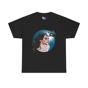 May include: Black t-shirt with a circular graphic of a woman with long dark hair. The woman is looking to the right and has a hand above her head. The graphic has a blue background with a white light shining down on the woman. The text "MAGICAL DISK" is written on the woman's chest.