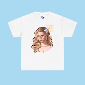 May include: White t-shirt featuring a portrait of a woman with blonde hair and a flower in her hair. The text "TRUE FRIENDS, TRUE HEARTS, THAT IS WHAT COUNTS IN LIFE" is printed in gold above the portrait. The shirt is a Champion brand.